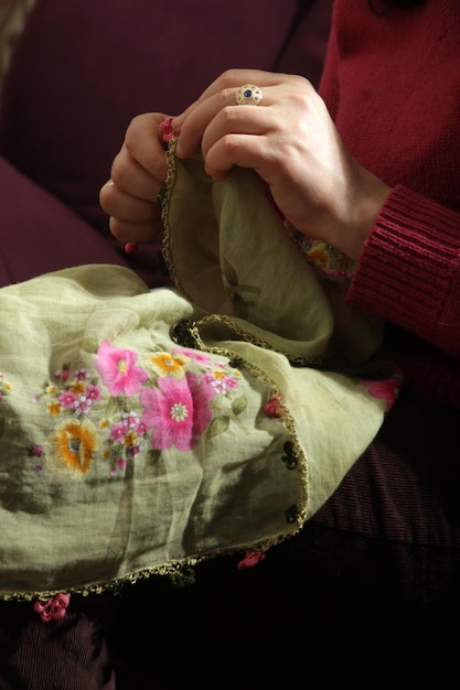 Ręce trzymające haftowaną tkaninę